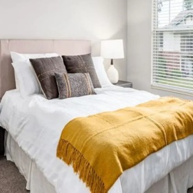 Styled bedroom with yellow throw blanket