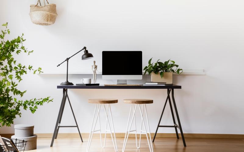 a desk with a laptop and stools